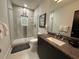 Modern bathroom with walk-in shower, granite vanity, and neutral tile at 331 Muirfield Loop, Reunion, FL 34747