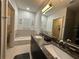Bathroom with double sinks, granite countertop and bathtub at 331 Muirfield Loop, Reunion, FL 34747