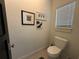 Simple and clean powder room with white toilet and framed artwork at 331 Muirfield Loop, Reunion, FL 34747