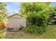 Small storage shed in backyard, surrounded by tropical plants at 180 N Lakewood Cir, Maitland, FL 32751