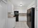 Galley kitchen with granite countertops and black appliances at 793 E Birchwood Cir, Kissimmee, FL 34743