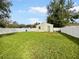 Large grassy backyard with a white fence and detached structure at 303 Carleton St, Lakeland, FL 33803