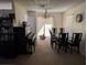 Bright dining room with glass table, six chairs, piano and natural light at 1301 Redwood Ct, Tavares, FL 32778