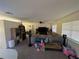 Spacious living room featuring a large sectional sofa and a flat-screen TV at 1301 Redwood Ct, Tavares, FL 32778