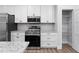 White shaker cabinets, granite countertops, and stainless steel appliances at 405 N Mcdonald Ave, Deland, FL 32724