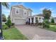 Two-story home with gray siding, brick accents, and a paver driveway at 488 Kistler Cir, Clermont, FL 34715