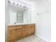 Bathroom with a double vanity, wood cabinets, and a large mirror at 2338 Silver Palm Dr, Kissimmee, FL 34747
