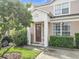 Townhome entrance with a red door and lush landscaping at 2338 Silver Palm Dr, Kissimmee, FL 34747
