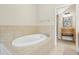 Relaxing bathroom with an oval-shaped bathtub and tile surround at 2960 Bella Vista Dr, Davenport, FL 33897