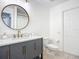 Modern bathroom with gray vanity, marble countertop, and a large round mirror at 693 Charrice Pl, Sanford, FL 32771