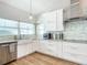 White kitchen with farmhouse sink and stainless steel appliances at 693 Charrice Pl, Sanford, FL 32771