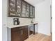 Modern wet bar with glass cabinets and quartz countertop at 693 Charrice Pl, Sanford, FL 32771