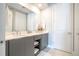 Modern double vanity bathroom with gray cabinets and a large mirror at 7740 Sandy Ridge Dr # 218, Reunion, FL 34747
