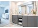 Double vanity bathroom with gray cabinets and a view into the bedroom at 7740 Sandy Ridge Dr # 218, Reunion, FL 34747