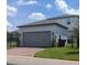 Detached two-car garage with gray doors and brick pavers at 12500 Encore At Ovation Way, Winter Garden, FL 34787