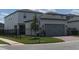 Two-car garage with gray doors and a black metal fence at 12500 Encore At Ovation Way, Winter Garden, FL 34787