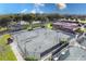 Aerial view of well-lit tennis courts with surrounding fencing at 38748 Lakeview Walk, Lady Lake, FL 32159