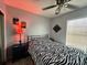 Bedroom with a zebra patterned comforter, ceiling fan and window blinds at 7317 Forest Hill Ct # 235, Winter Park, FL 32792