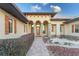 Elegant entryway with arched entry, stone accents, and meticulously landscaped grounds at 38748 Lakeview Walk, Lady Lake, FL 32159