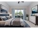 Bright bedroom with a king-size bed, dresser, and sliding glass doors to a patio at 38748 Lakeview Walk, Lady Lake, FL 32159
