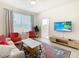 Living room with a sofa, armchairs, and a large TV, plus access to a balcony at 2809 Almaton Loop # 304, Kissimmee, FL 34747