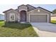 Newly constructed home with two-car garage and well-manicured lawn at 279 Fig Ct, Poinciana, FL 34759