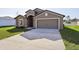 New house with driveway, two-car garage, and grassy front yard at 279 Fig Ct, Poinciana, FL 34759