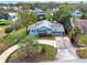 Single-story light blue house with a circular driveway, surrounded by lush greenery at 504 Osceola Ave, Eustis, FL 32726