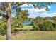 Peaceful backyard view of a lake under a partly cloudy sky at 504 Osceola Ave, Eustis, FL 32726