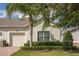 Tan house with a two-car garage and manicured landscaping at 3825 Quaint Ln # F, Clermont, FL 34711