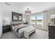 Main bedroom with plush bed, accent wall, and large windows at 4789 Sparkling Shell Ave, Kissimmee, FL 34746