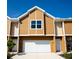 Exterior of tan two-story home with a white garage door at 107 Oceans Cir, Daytona Beach Shores, FL 32118