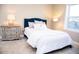 Bedroom with a blue headboard, white bedding, and a wooden nightstand at 107 Oceans Cir, Daytona Beach Shores, FL 32118