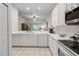 Open kitchen with white cabinets and stainless steel appliances at 101 New Providence # 9101, Davenport, FL 33897