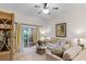 Living room features beige couch, wicker furniture, and access to a screened-in patio at 101 New Providence # 9101, Davenport, FL 33897
