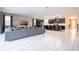 Open concept living area with kitchen and gray sectional sofa at 9043 Sunshine Ridge Loop, Kissimmee, FL 34747