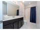 Bathroom with a shower/tub combo, dark vanity, and white tile at 9043 Sunshine Ridge Loop, Kissimmee, FL 34747