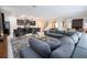 Open floor plan with gray sectional and kitchen views at 9043 Sunshine Ridge Loop, Kissimmee, FL 34747