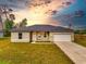 Single-story home with a two-car garage and grassy yard at 1910 Lakeview Ln, Poinciana, FL 34759
