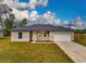 Single-story home with a two-car garage and grassy yard at 1910 Lakeview Ln, Poinciana, FL 34759