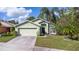 Charming light green house with a two-car garage and palm trees at 803 Sandy Ridge Dr, Davenport, FL 33896