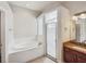 Elegant bathroom with a soaking tub, walk-in shower, and granite vanity at 6311 Alamanda Hills Dr, Lakeland, FL 33813