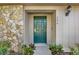 Inviting house entrance with a teal door, stone accents, and lush landscaping at 734 Riverbend Blvd, Longwood, FL 32779