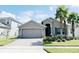Single-story home with gray exterior, paver driveway, and lush landscaping at 3995 Scarlet Branch Rd, Orlando, FL 32824