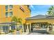 Hotel entrance with covered awning and landscaping at 3000 Maingate Ln # 113, Kissimmee, FL 34747