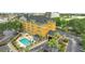 Aerial view of a hotel featuring a pool, parking lot, and surrounding landscape at 3000 Maingate Ln # 113, Kissimmee, FL 34747