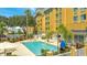 Refreshing hotel pool with lounge chairs and umbrellas at 3000 Maingate Ln # 113, Kissimmee, FL 34747
