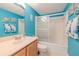 Bright bathroom with light blue walls, a tub shower combo, and wood vanity at 5501 S Atlantic Ave # 307, New Smyrna Beach, FL 32169