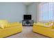 Sitting area with two yellow chairs and TV at 5501 S Atlantic Ave # 307, New Smyrna Beach, FL 32169