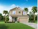 Two-story house with a two-car garage and palm trees at 4239 Sagefield Dr, Harmony, FL 34773